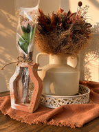 Vase ajouré terracotta et blanc accueillant une fleur en cire végétale