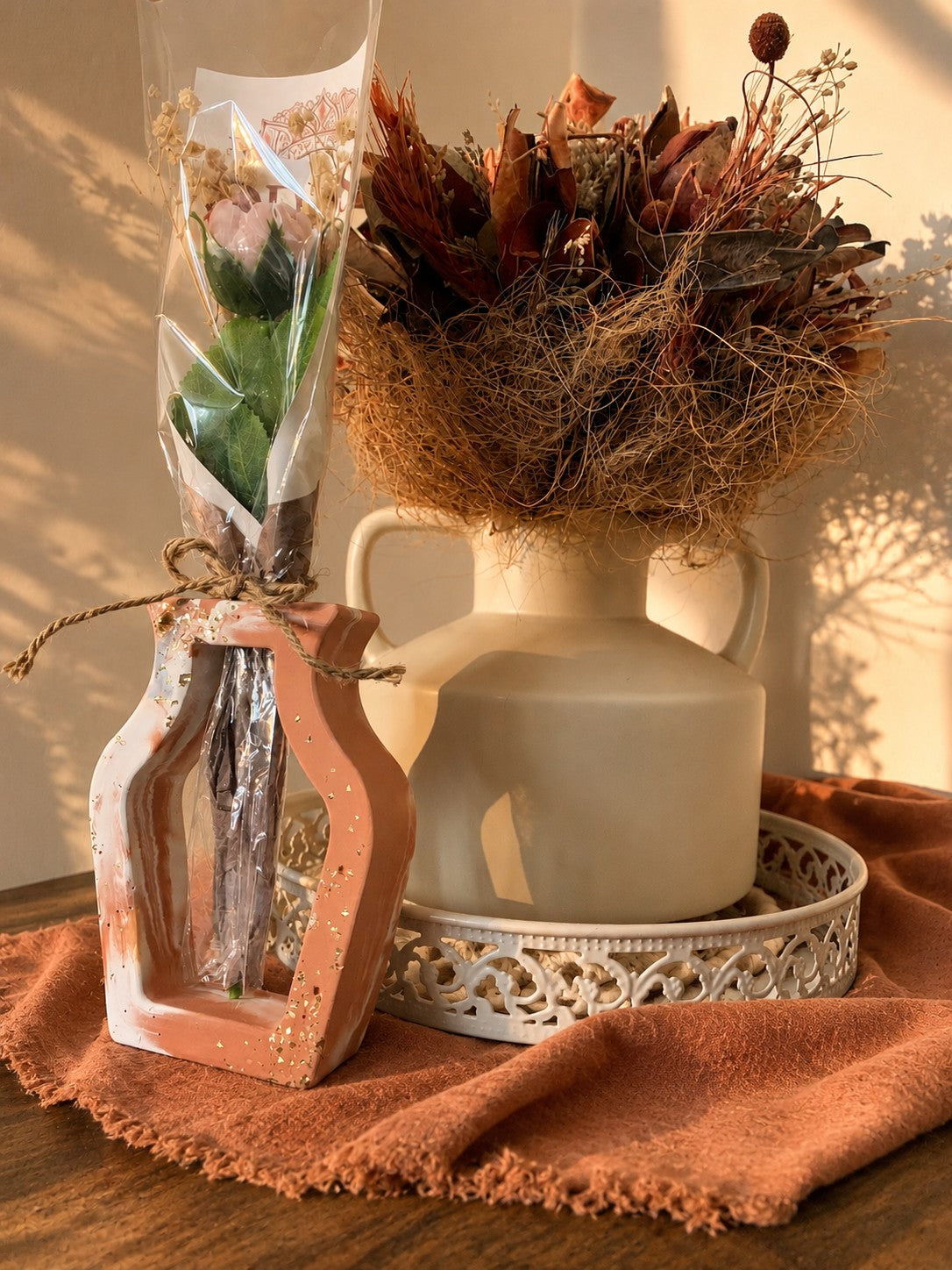 Vase ajouré terracotta et blanc accueillant une fleur en cire végétale