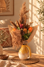 Bouquet d'automne en cire végétale Ambre Sauvage dans un pichet jaune, roses orangées et herbes séchées