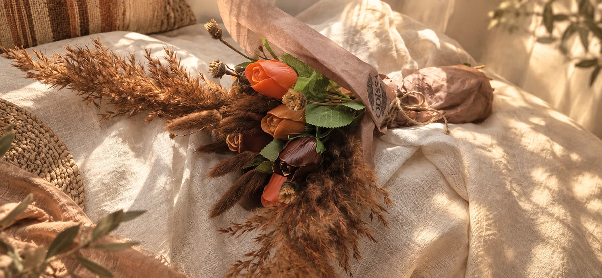 Bouquet en cire végétale Odissa emballé dans un papier kraft fermé d'une ficelle, teintes orangées et brunes