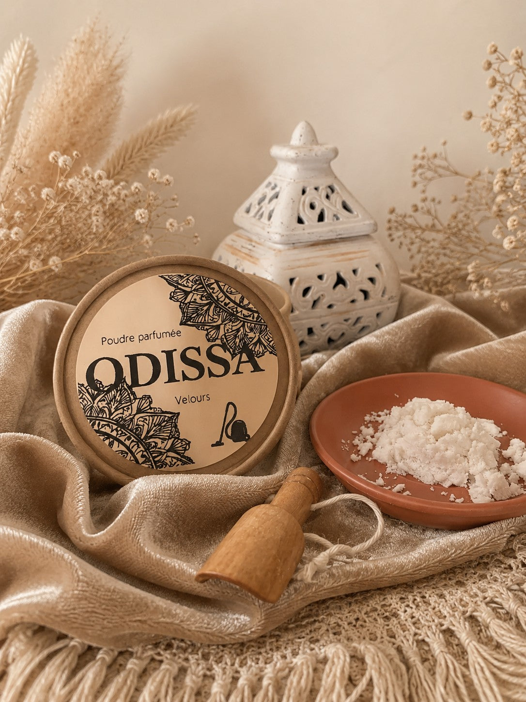 Poudre aspirateur parfumée Odissa Velours – boîte kraft posée sur tissu doré avec coupelle terracotta et cuillère en bois