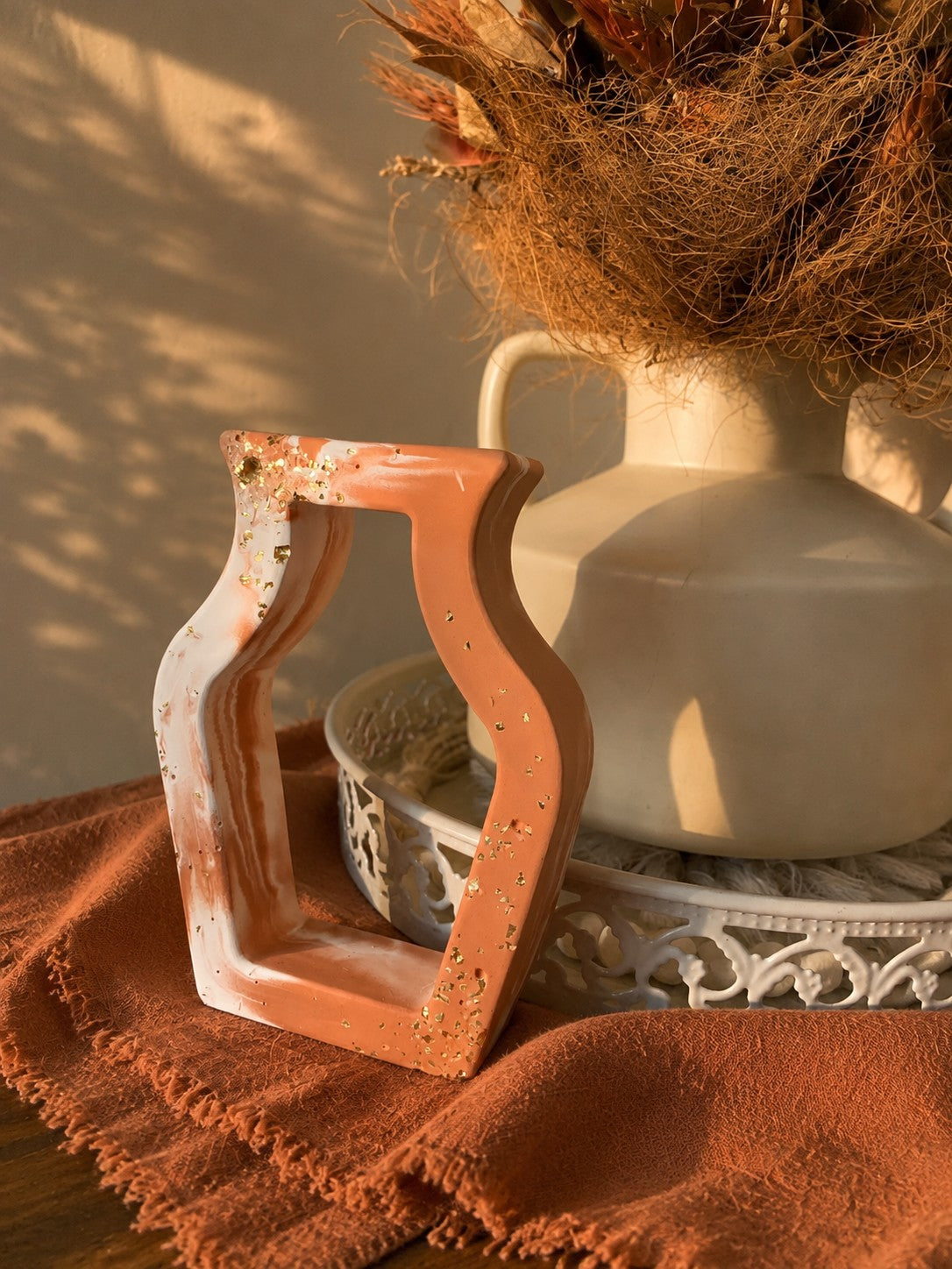 Détail de la structure ajourée du vase terracotta et blanc en résine minérale et de ses incrustation doré