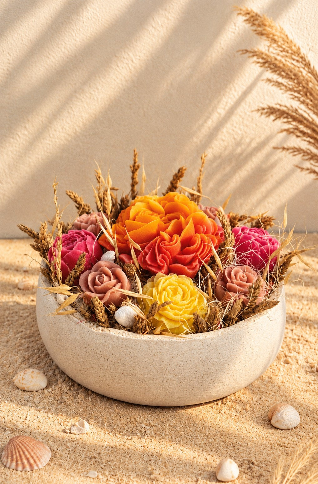 Composition florale Rivage d'Été en cire végétale, vue rapprochée sur le dahlia jaune soleil, la pivoine orange et les pivoines fuchsia parmi les fleurs séchées