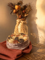 Composition florale Odissa en cire végétale dans vasque résine minérale effet marbre, mise en scène avec vase en corde et bouquet séché