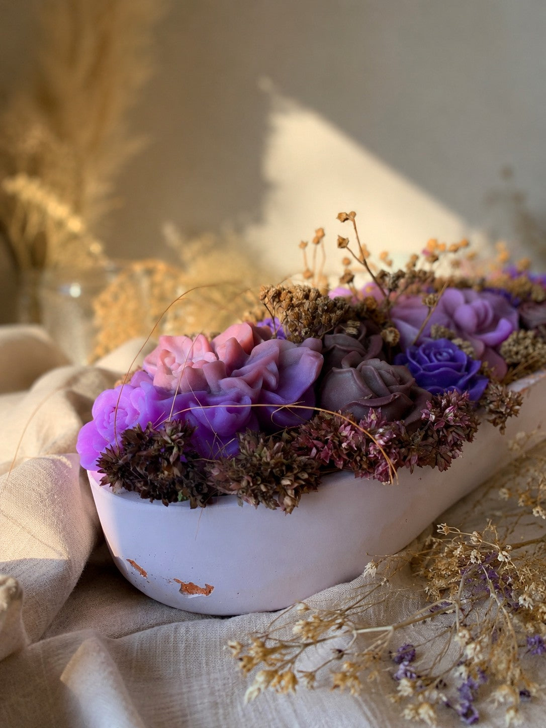 Composition florale Mauve Précieux en cire végétale, vue de face avec fleurs mauves, violettes et roses anciennes dans une vasque blanche