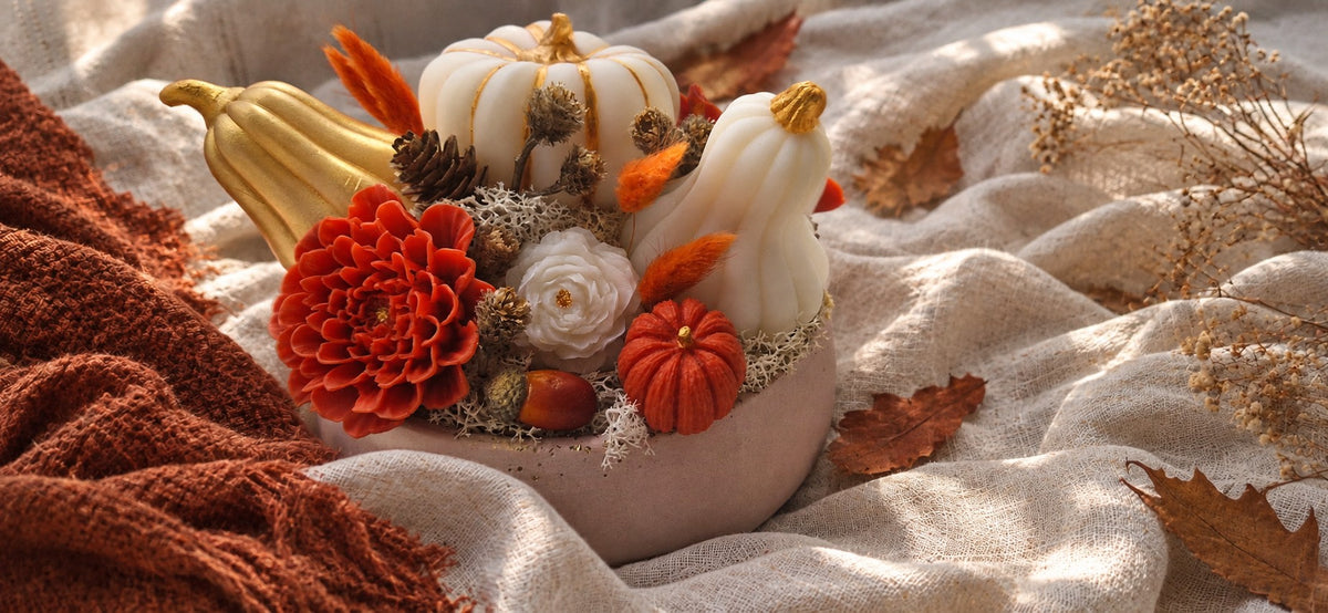 Composition florale d'automne en cire végétale Éclat d'Automne : citrouille blanche dorée, fleurs terracotta et fleurs séchées dans une coupe ronde