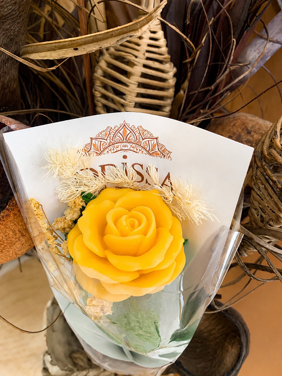 Gros plan de la rose jaune en cire végétale et de son emballage Odissa