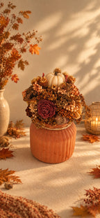 Petite composition florale d'automne en cire végétale, tons chauds dorés, citrouille ivoire et pot côtelé terracotta