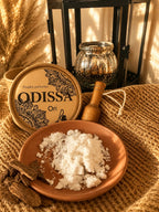 Poudre aspirateur parfumée Odissa Ori 100 g, boîte ouverte avec poudre blanche et cuillère en bois dans un décor chaleureux